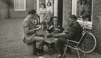 875781 Portret van drie kaartspelende mannen voor de woning Oranjehof 20 in Wijk C te Utrecht, met v.l.n.r. Lowie van ...